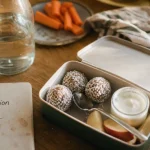 Idées de collations saines : energy balls, yaourt et pomme sur une table